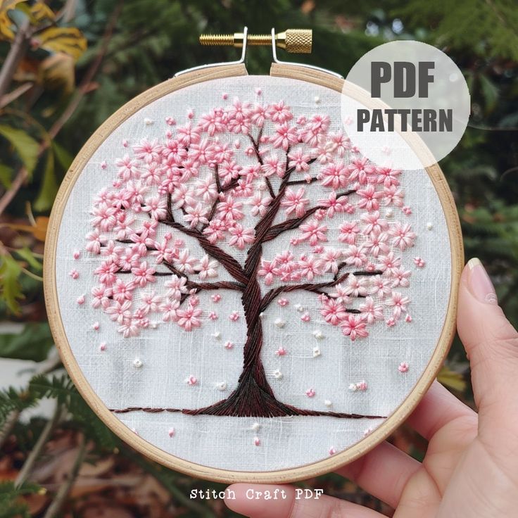 a hand embroidered tree with pink and white flowers