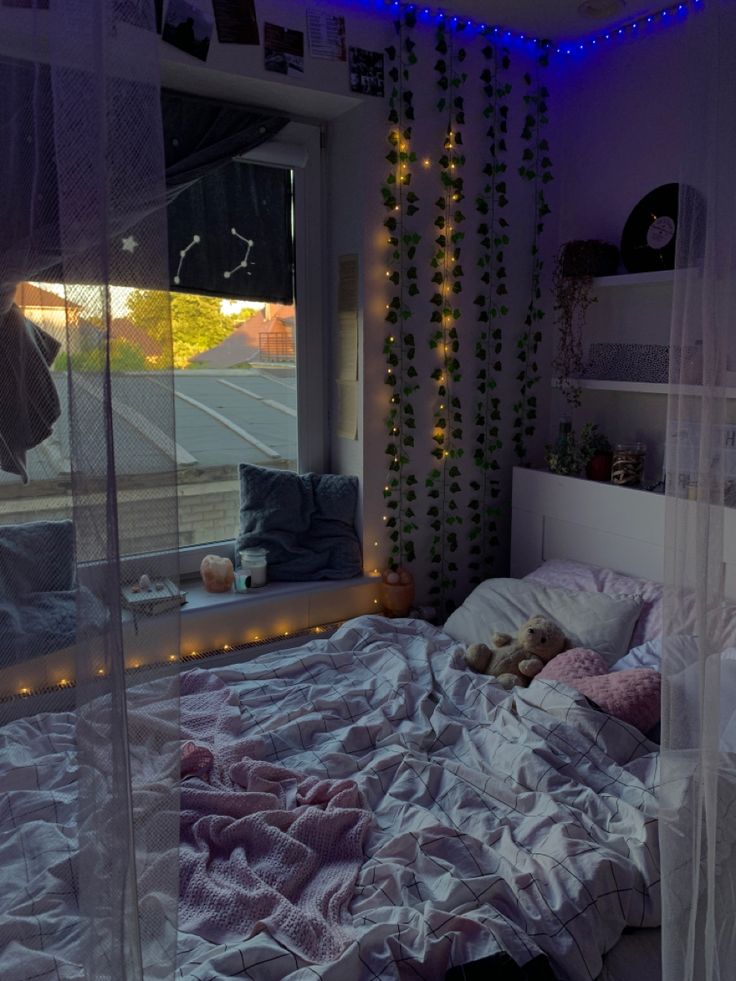 a dog laying on top of a bed in a room with purple sheets and lights