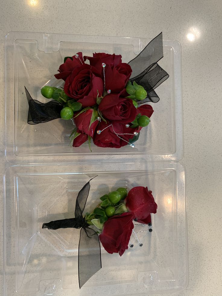 two plastic trays with red flowers and black ribbons on them, one is empty