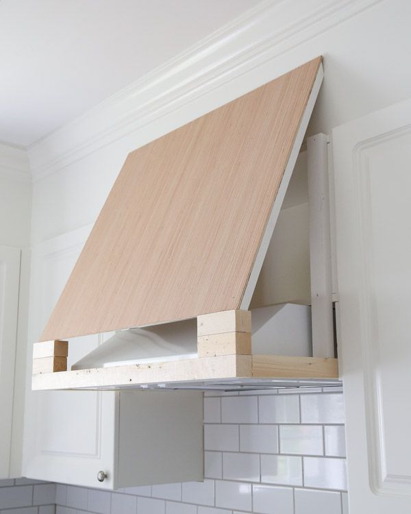 a kitchen stove with a wooden hood over it