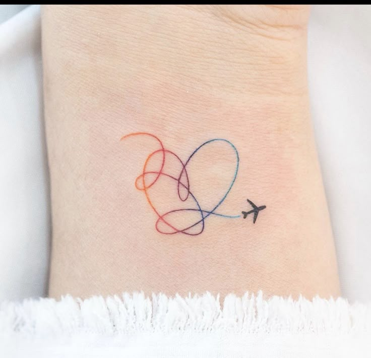 a small tattoo on the ankle of a woman with an airplane flying in the sky