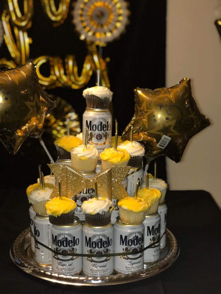 cupcakes are arranged on top of each other in front of some gold foil balloons