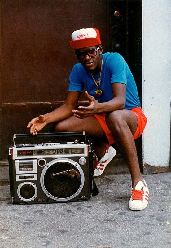 a man sitting on the ground next to an old radio