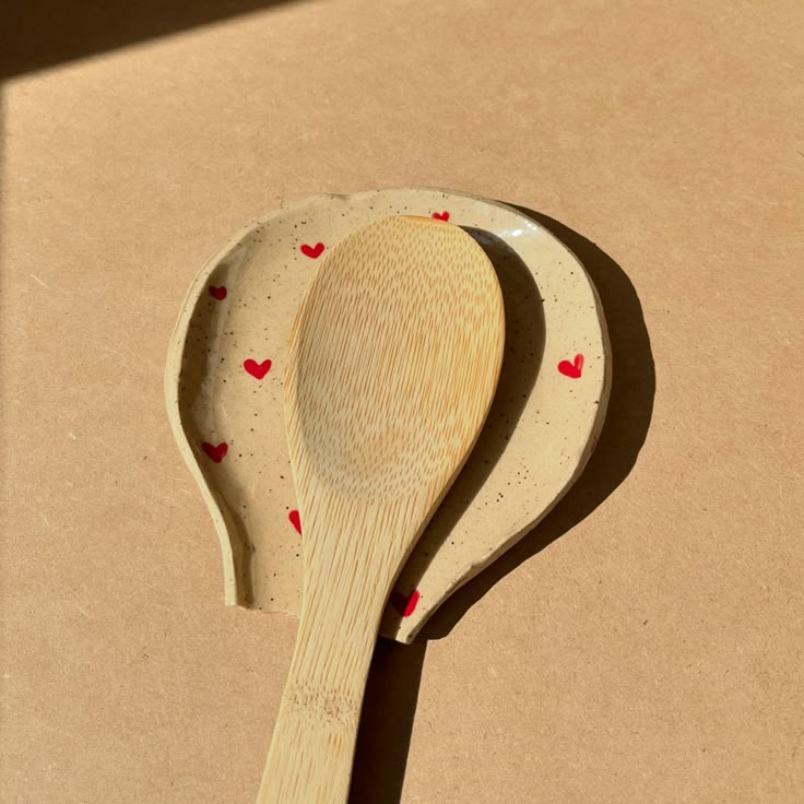 a wooden spoon with red hearts on it