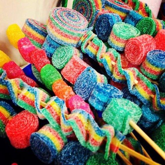 many colorful lollipops are stacked on sticks