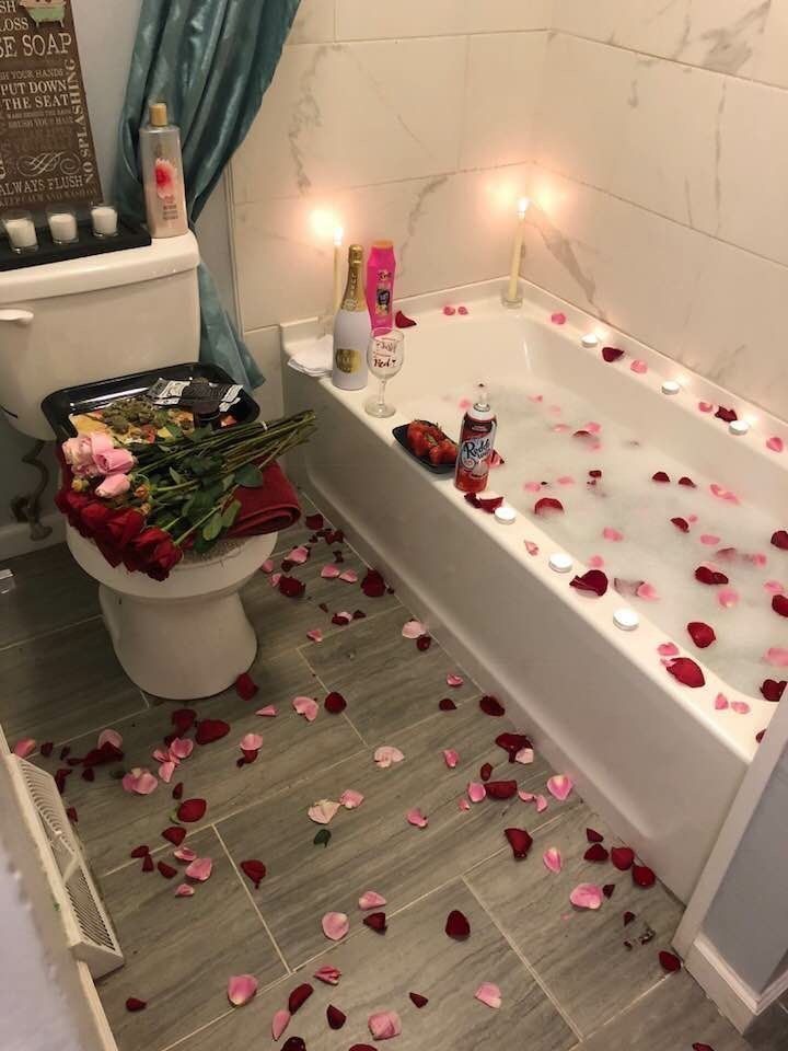 the bathroom is decorated with rose petals and candles