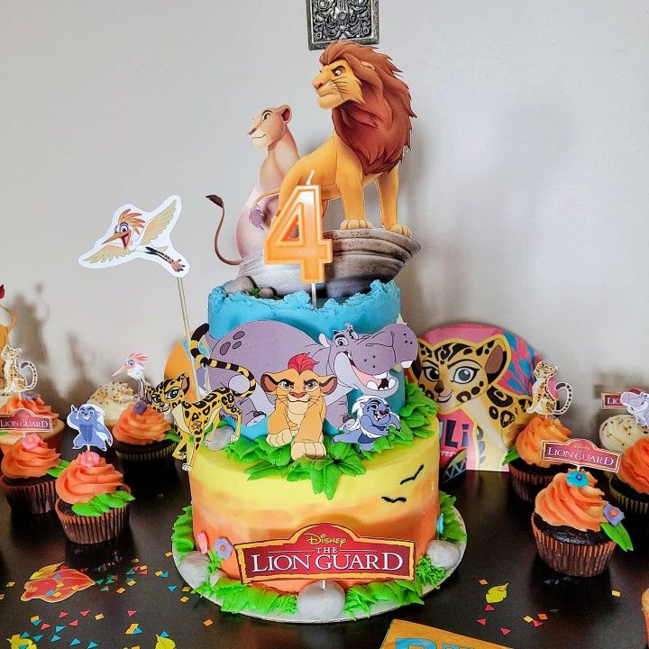 the lion king birthday cake is surrounded by cupcakes and other decorations on a table