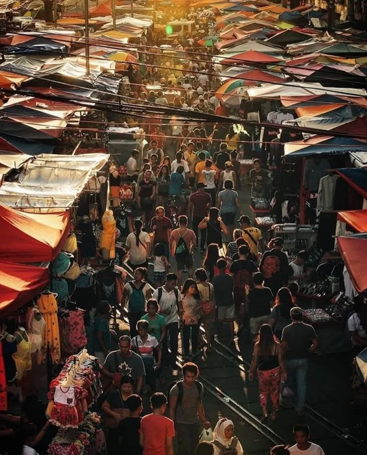 an overhead view of a crowded market with people walking through the stalls and vendors selling their goods