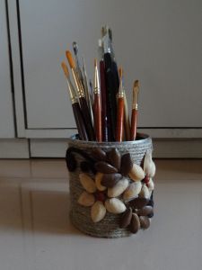 a close up of a cup with pens and pencils in it