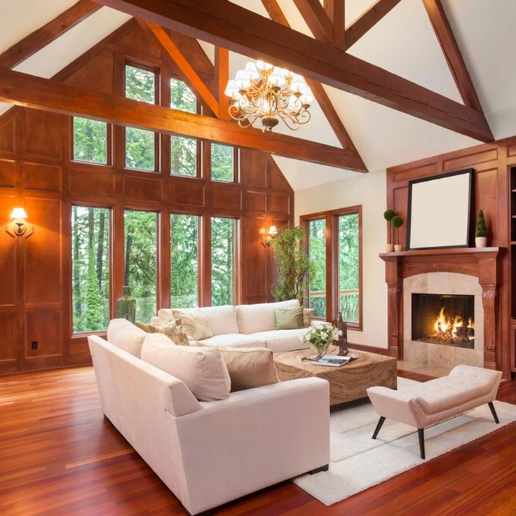 a large living room with wood floors and high vaulted ceilings, white couches and fireplace