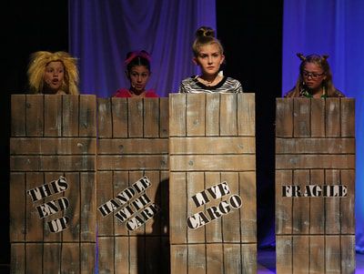 three girls are standing behind wooden blocks with words on them that spell out live cargo