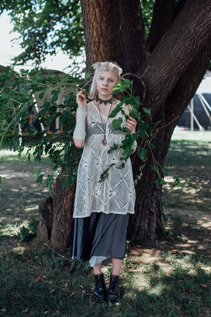 a woman standing in front of a tree