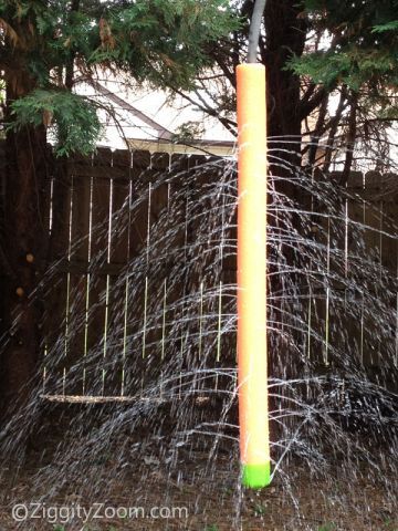 an orange and yellow pole in the middle of a yard