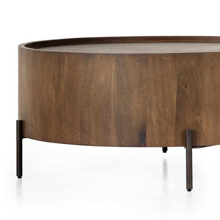 an oval wooden table with metal legs and a wood top that has been turned into a coffee table