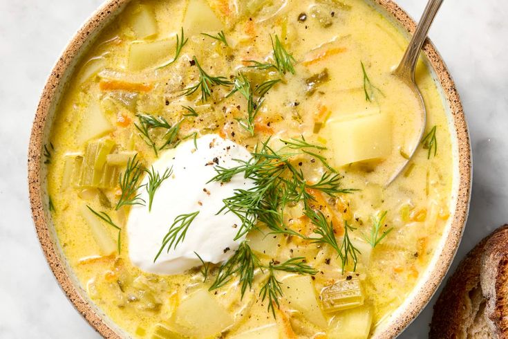 a bowl of soup with bread and sour cream