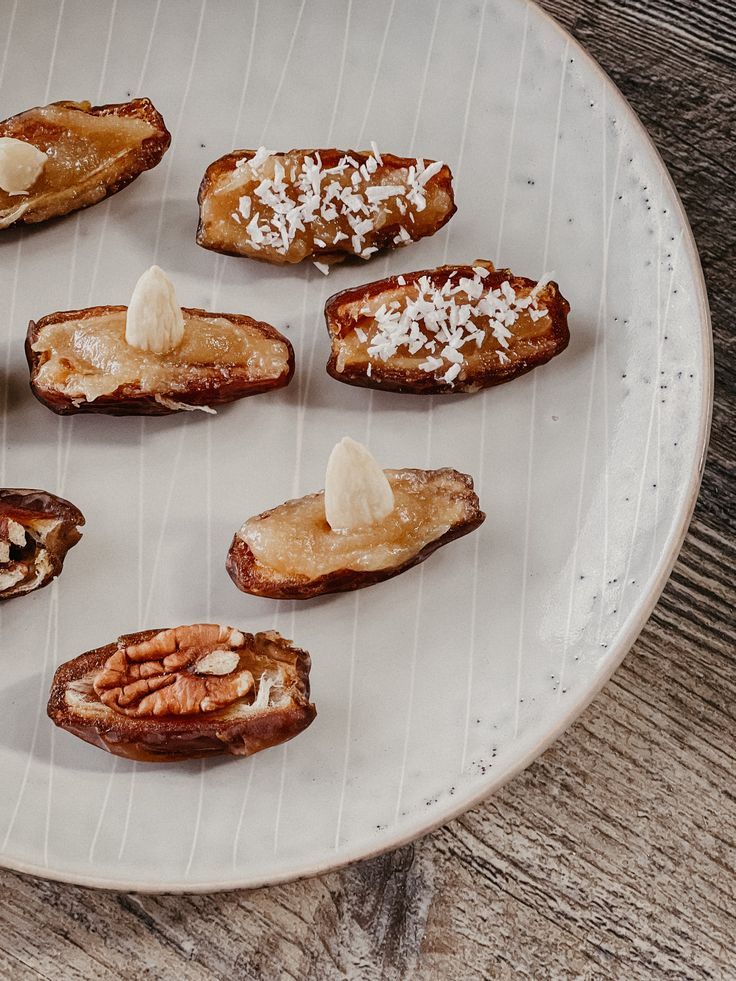 an assortment of baked goods displayed on a white plate with wood grained table top