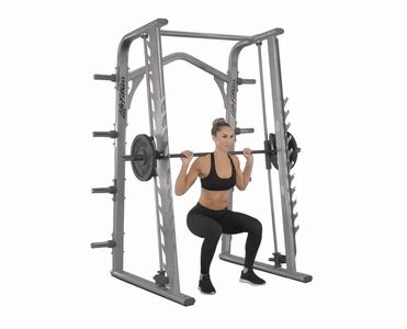 a woman squats in front of the barbell rack with one hand on her hip