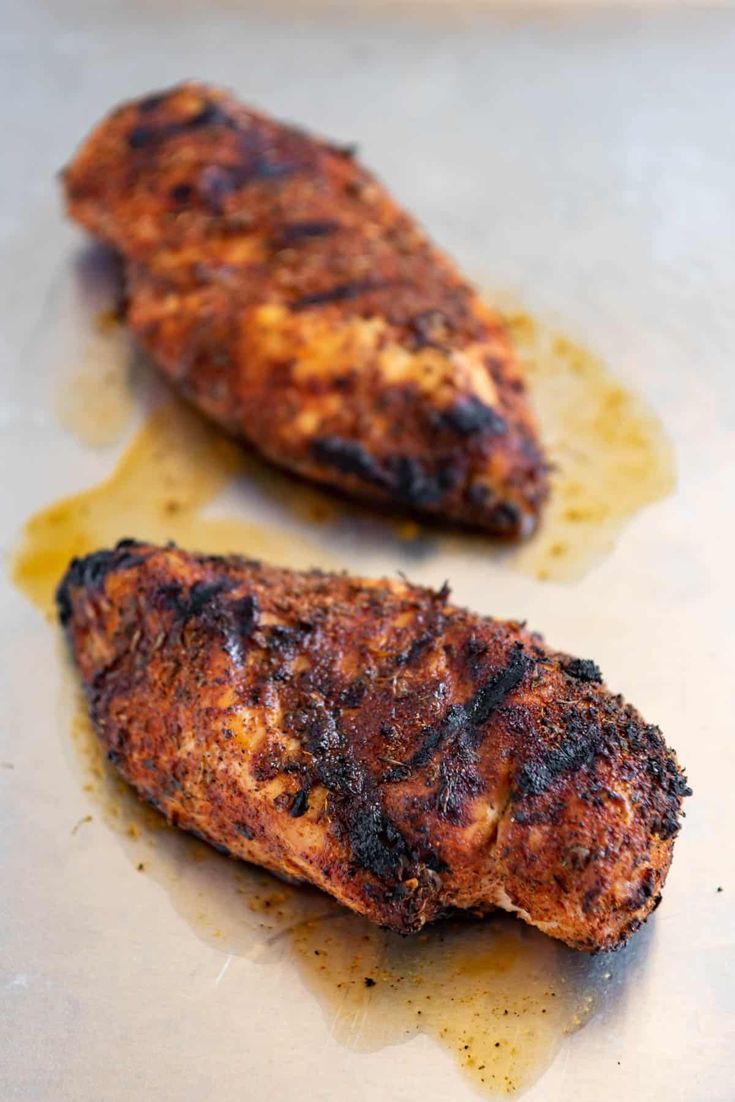 two pieces of meat sitting on top of a table