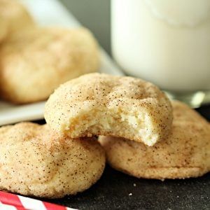 some sugar cookies are on a table next to a glass of milk and straws