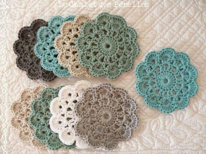 several crocheted doily are arranged on a quilt