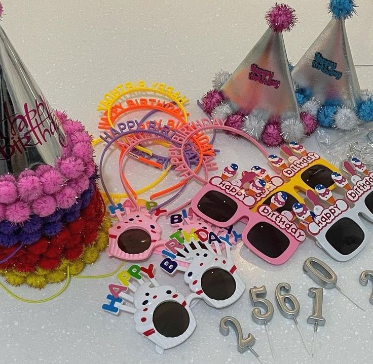 several birthday hats, sunglasses and decorations on a table