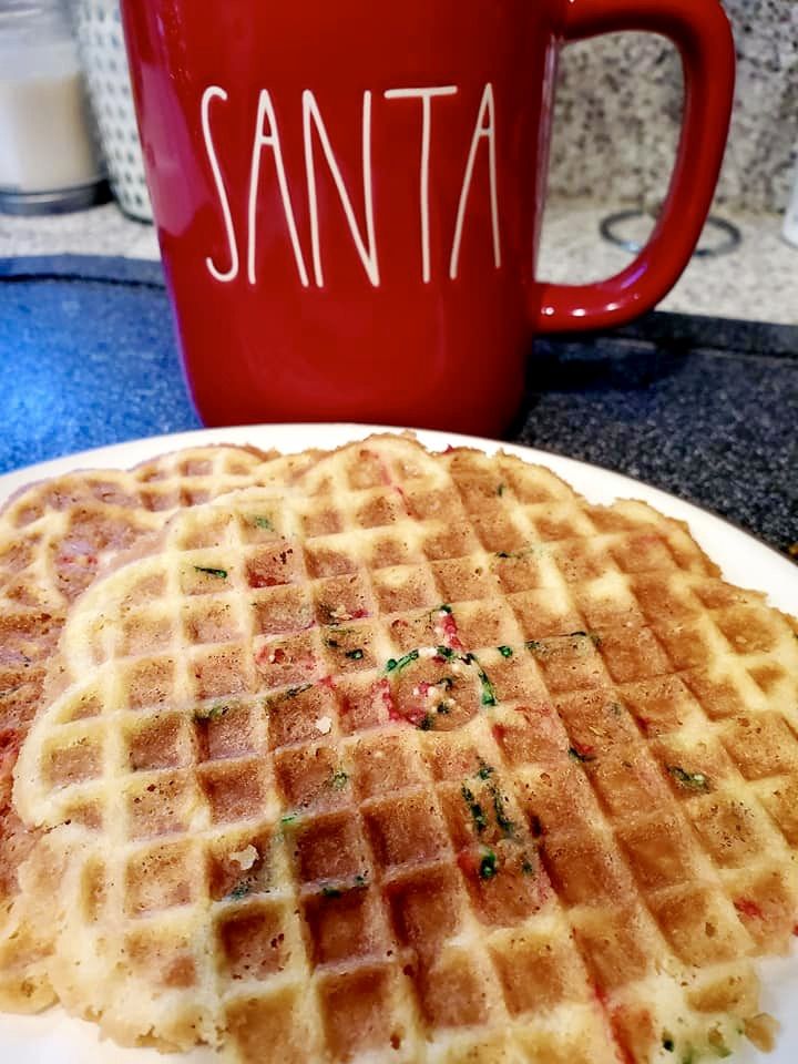 a stack of waffles sitting on top of a white plate next to a red coffee mug