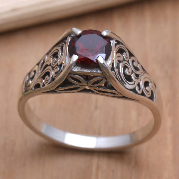 Accented with a pretty floral motif Agung Jagra's cocktail ring features a glowing garnet stone in a decorative prong setting. The Balinese artisan hand crafts the band from sterling silver engraving the precious metal with swirling openwork designs. Formal Red Garnet Filigree Ring, Garnet Filigree Ring As Gift, Garnet Filigree Ring, Ornate Silver Ruby Ring Hallmarked, Victorian Garnet Silver Ring, Irish Wedding Rings, Garnet Ring Vintage, Garnet Ring Silver, Silver Cocktail