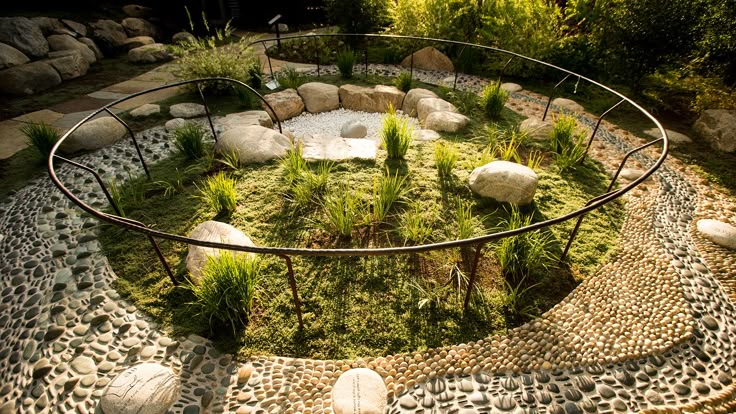 a circular garden with rocks and plants in it