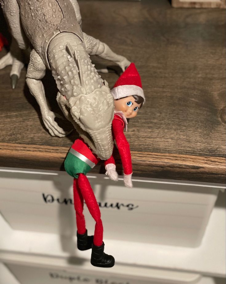 an elf is standing on top of a shelf with his head in the back of a dragon figurine