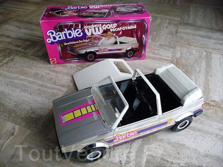 a toy car is sitting on the floor next to a box with its door open