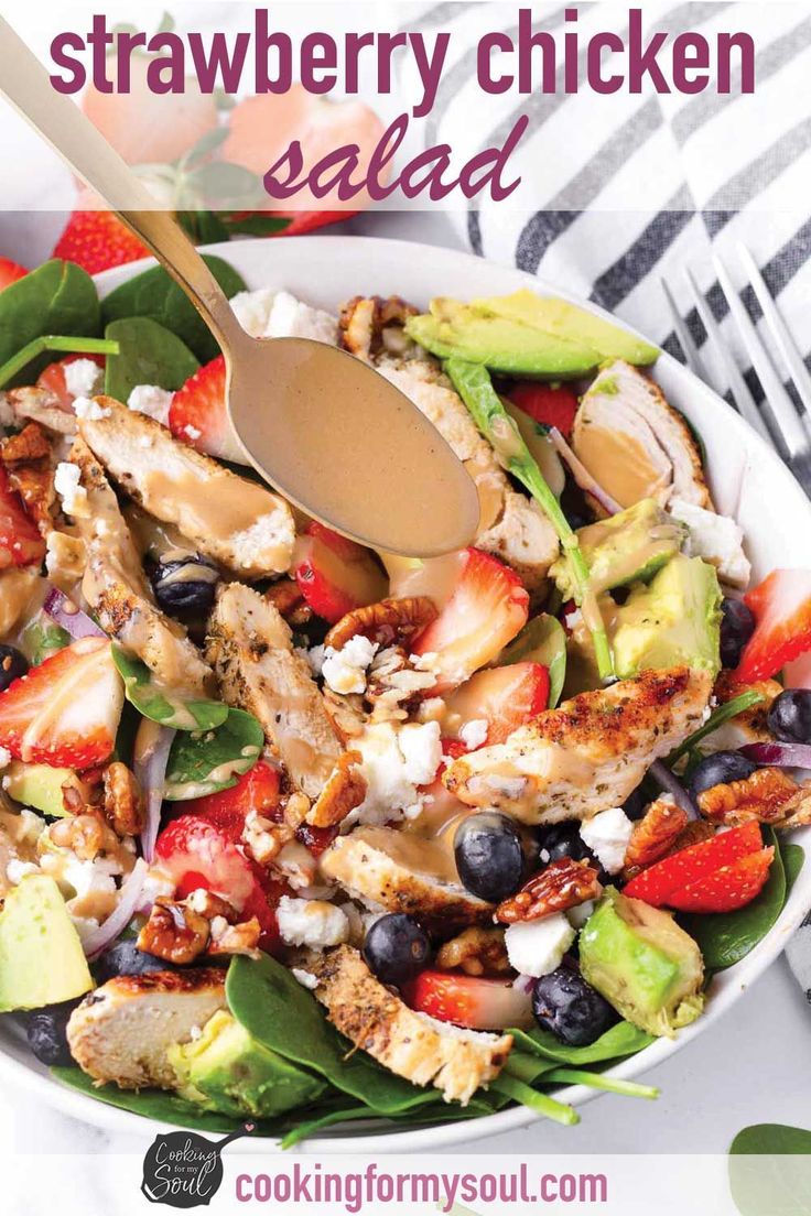 a salad with chicken, avocado, strawberries and feta cheese