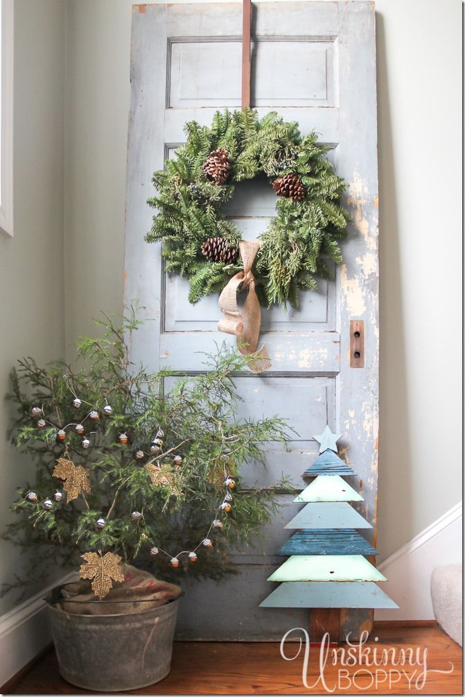 an old door is decorated with wreaths and pine cones