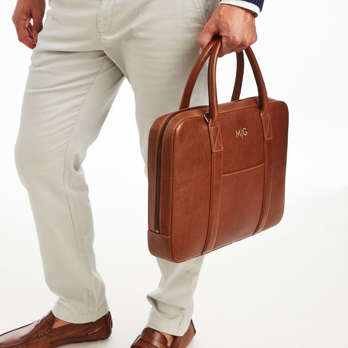 Handsome and distinguished, Carson is an elevated travel collection, made from gorgeous calf leather, with numerous practical details. The briefcase has classic styling with both a handle and adjustable carrying strap, plus multiple pockets and compartments for commuting or work travel. Make it even more personal with a laser-engraved monogram.  15"w x 2.5"d x 11.25"h  Please see Product Information for more dimensions.  Calf leather, cotton lining.  Lightly finished leather will age and patina Classic Briefcase With Luggage Sleeve For Travel, Classic Cognac Travel Bag For Business Trips, Luxury Cognac Briefcase With Luggage Sleeve, Timeless Leather Lined Laptop Bag For Travel, Classic Satchel With Luggage Sleeve, Classic Satchel Luggage With Sleeve, Classic Satchel Case With Luggage Sleeve, Classic Brown Leather Office Travel Bag, Classic Business Travel Bag With Leather Handles