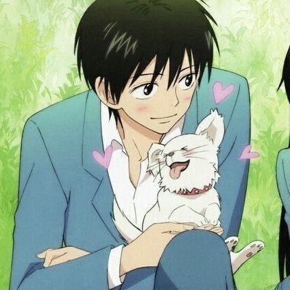 a man in a suit holding a small white dog with hearts on it's chest