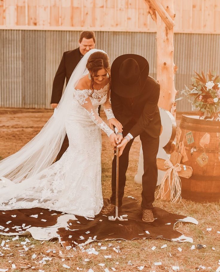 a bride and groom are cutting their wedding cake with an old - fashioned top hat