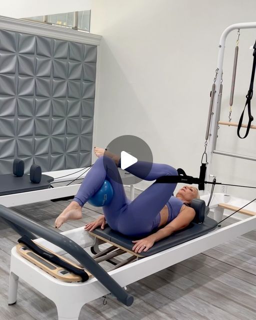 a woman is doing an exercise on a pivot machine in a room with other equipment