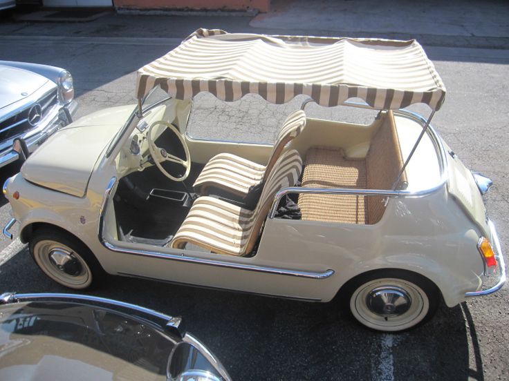 an old car is parked in a parking lot