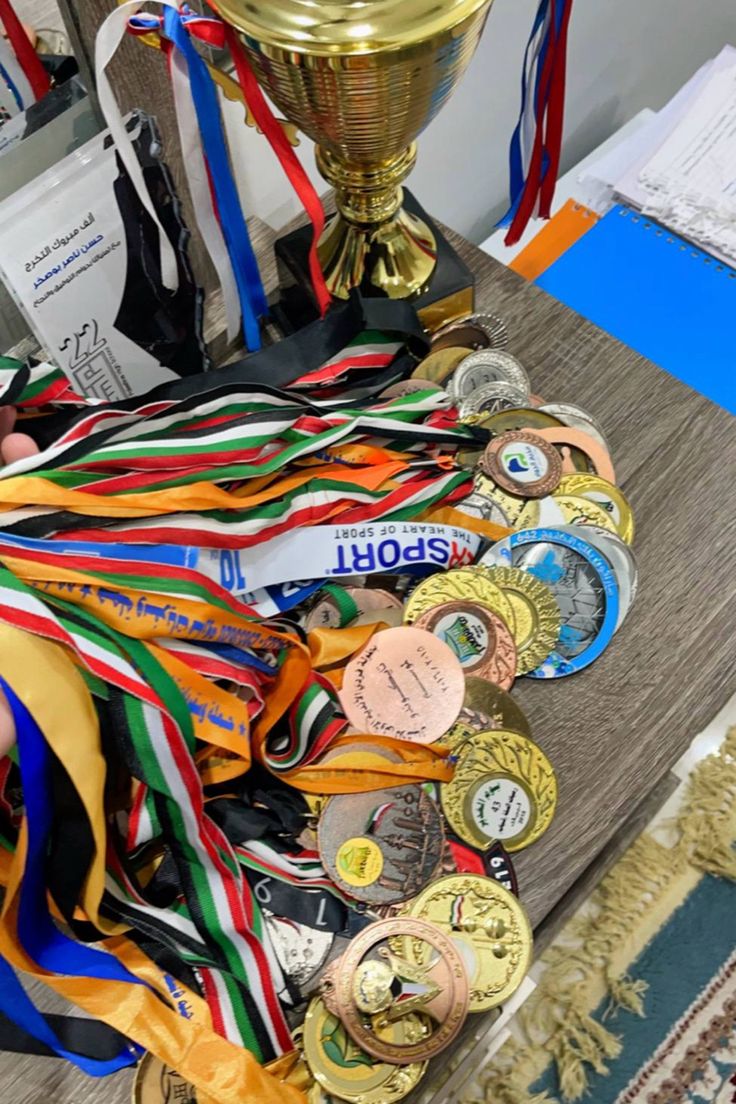 a table topped with lots of medals next to a trophy