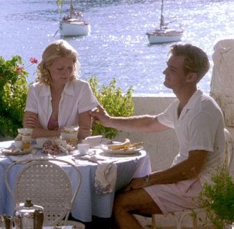 a man and woman sitting at a table with food