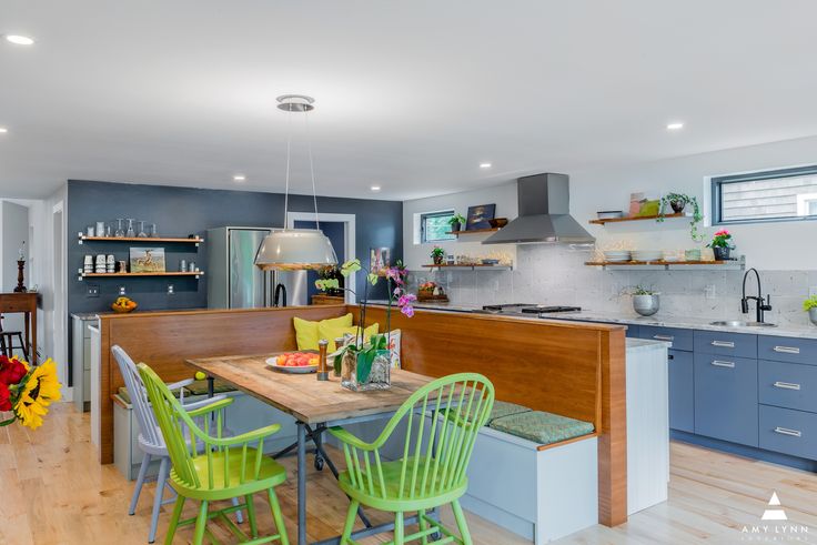 a kitchen with blue cabinets and green chairs