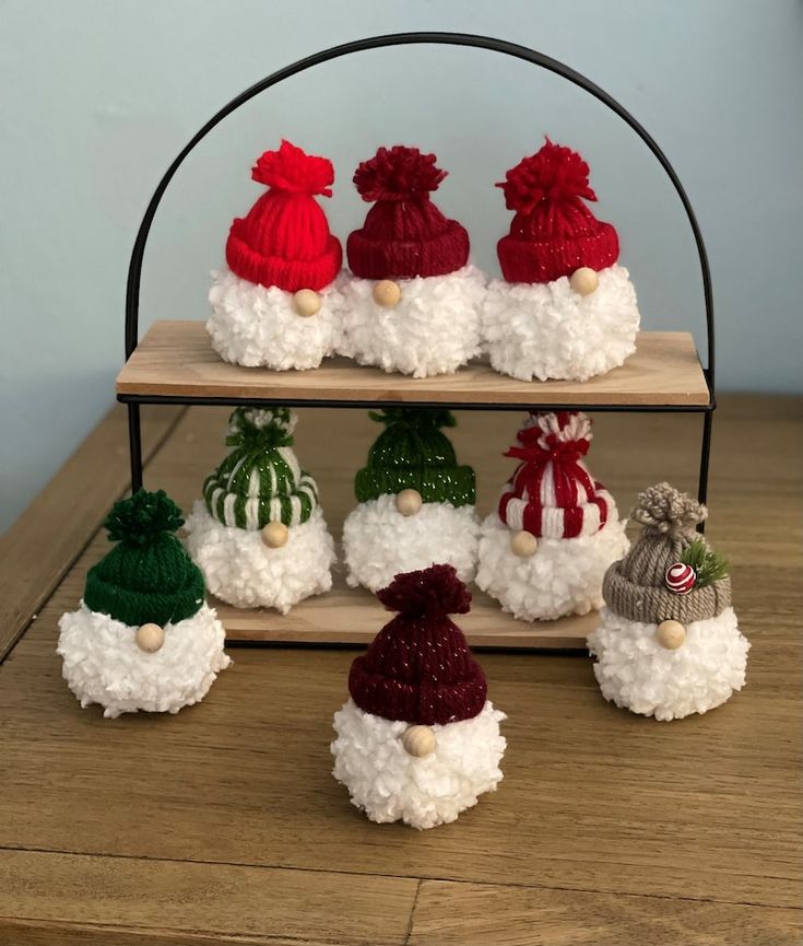 small knitted santa hats are displayed on a shelf