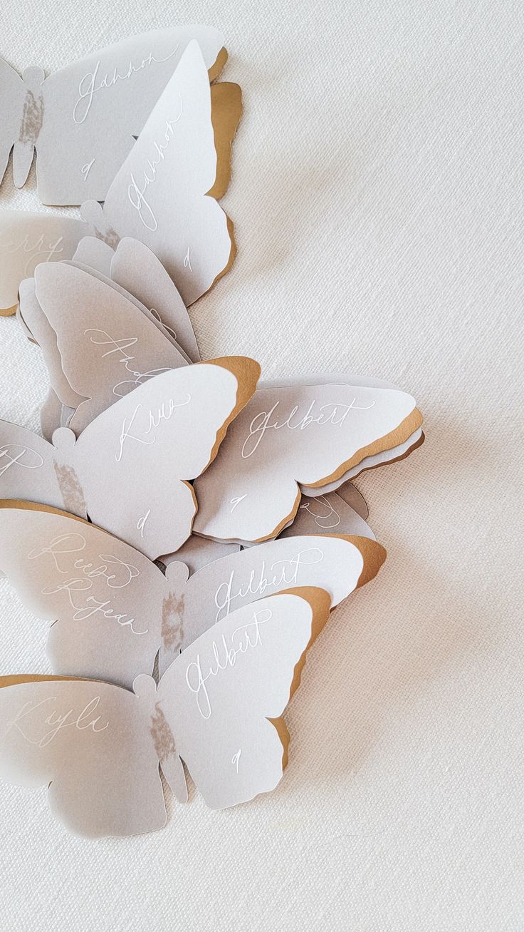 some white and brown paper butterflies with writing on them