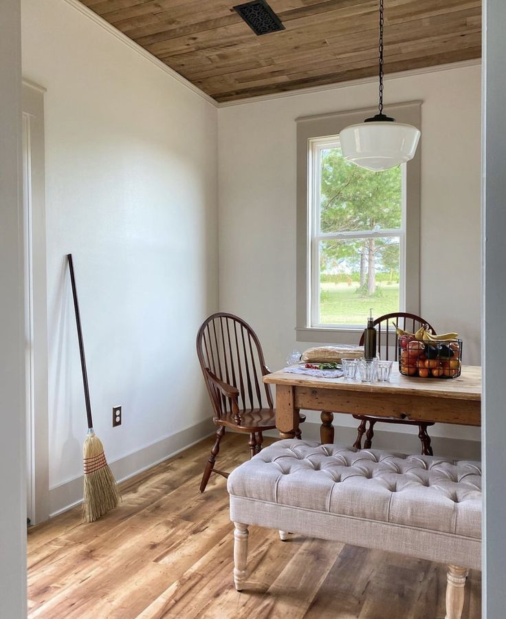 a dining room table with two chairs and a broom