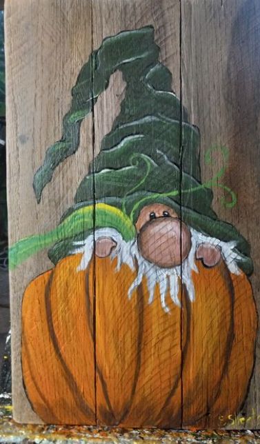 a piece of wood that has been painted with pumpkins