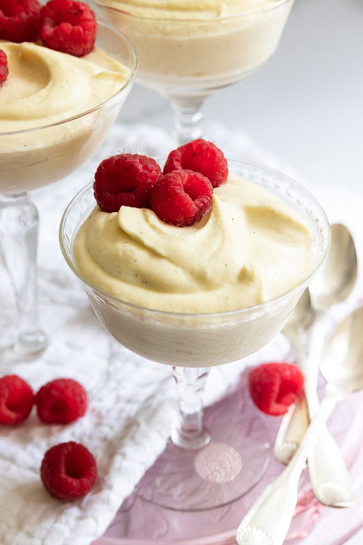 three desserts with raspberries in small glasses