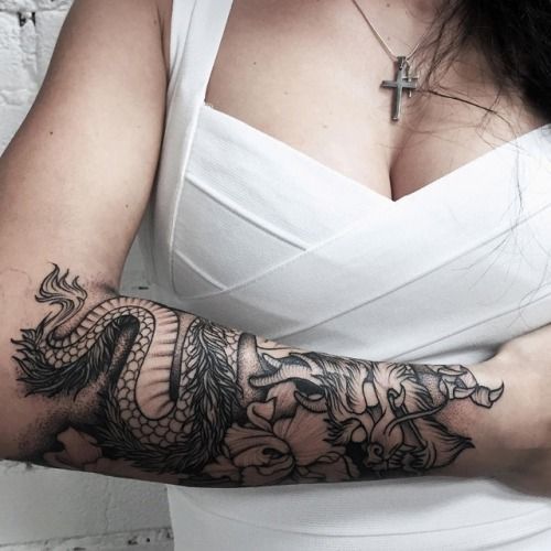 a woman with a dragon tattoo on her arm