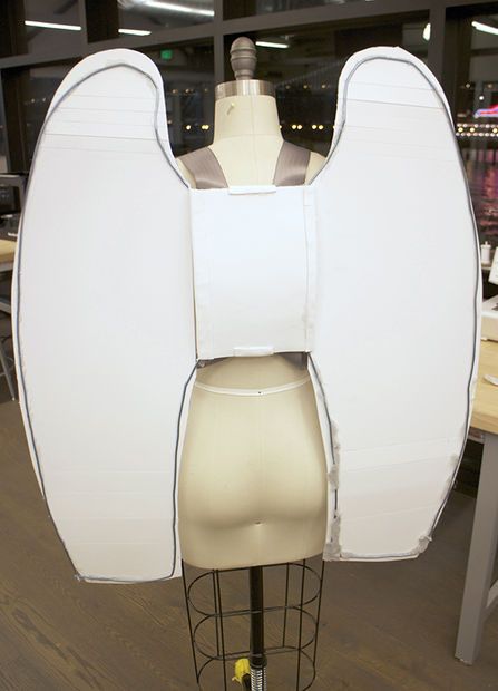 a mannequin's head is made out of white paper and sits on a stand