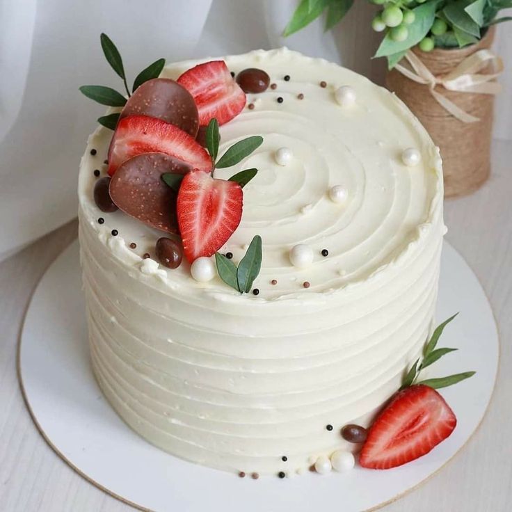 a white cake with strawberries and chocolate on top