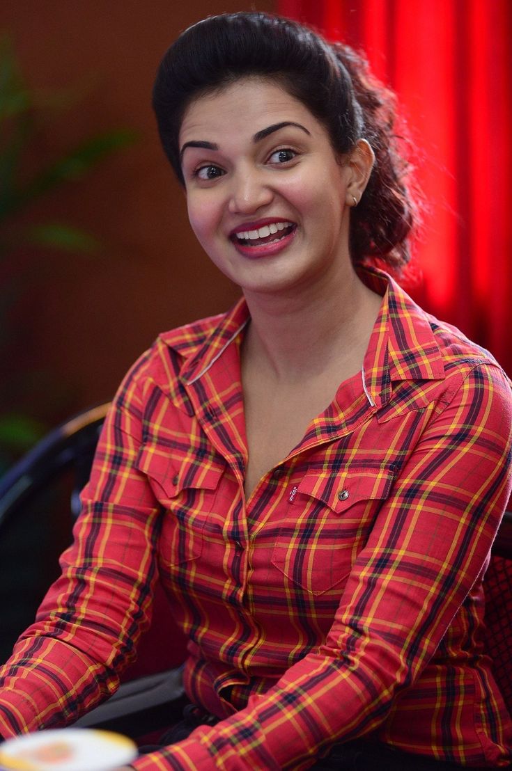 a smiling woman sitting at a table with food