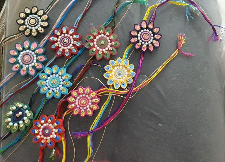 several different colored flowers are on the ground next to some string and beads, which have been made into hair clips